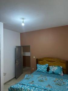 Schlafzimmer mit einem Bett mit blauer Decke in der Unterkunft Logé express in Douala