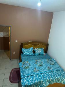 ein Bett mit blauer Decke in einem Schlafzimmer in der Unterkunft Logé express in Douala