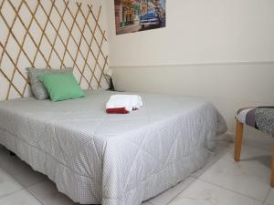 a bedroom with a bed with a green and white blanket at T2 Av. 25 de Abril - 2 minutos a pé da praia -Sunny Beach in Costa da Caparica