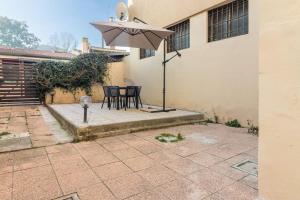 a patio with a table and an umbrella at [Debe-A due passi da StazioneFs] in Ferrara