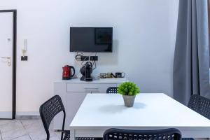 a white table with chairs and a tv on a wall at [Debe-A due passi da StazioneFs] in Ferrara