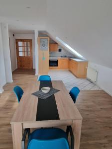 a dining room with a table and blue chairs at FerienApartment - FeWo Weitblick in Sassenburg