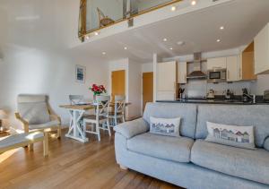 a living room with a couch and a kitchen at Quayside in Porthleven