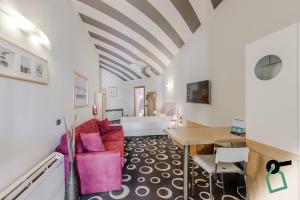 un soggiorno con divano rosso e tavolo di HOTIDAY ApartHotel Firenze a Firenze