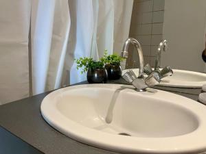 - un lavabo blanc dans une salle de bains avec 2 plantes dans l'établissement Bienvenue, à Montrouge