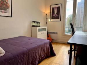 - une chambre avec un lit, un bureau et une table dans l'établissement Bienvenue, à Montrouge
