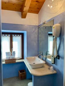 bagno blu con lavandino e specchio di Relais Fontana Rosa B&B Wellness a Caprino Veronese