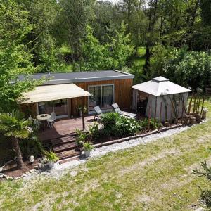 a small cabin with a deck and an umbrella at Quinta Miminel in Rabuide