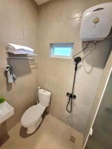 a bathroom with a toilet and a camera in it at Zizi Homey Cemara Asri Triple Room 202 in Medan