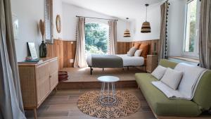 a living room with a bed and a couch at Le Pavillon - Les Lodges de Praly in Les Ollières-sur-Eyrieux