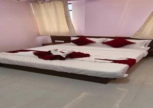 a bedroom with two beds with red pillows at Hotel Kharadi Inn in Pune