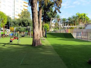 um parque com uma árvore e um parque infantil em Trinacria House - Appartamento Deluxe Comiso em Comiso