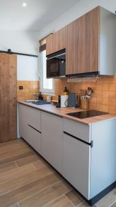 una cocina con armarios blancos y encimeras de madera en Le Pavillon - Les Lodges de Praly en Les Ollières-sur-Eyrieux