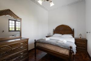 1 dormitorio con cama, tocador y espejo en GuestReady - Rustic Oasis in Vila Nova de Cerveira, en Vila Nova de Cerveira