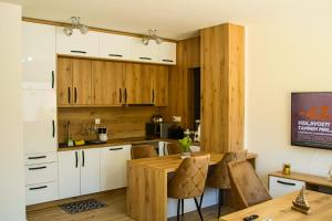 una cucina con mobili bianchi e un tavolo di legno di Vila Biser Vodice a Vodice