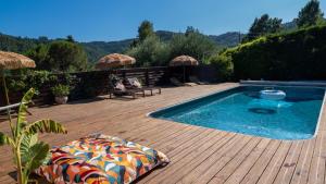 a swimming pool sitting on a wooden deck next to a wooden deck at Le Pavillon - Les Lodges de Praly in Les Ollières-sur-Eyrieux