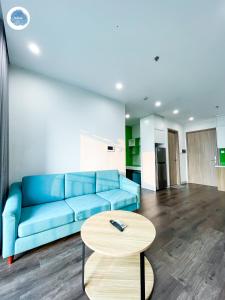 - un salon avec un canapé bleu et une table dans l'établissement It Dust Homestay 6 - The Forest Apartment, à Gia Lâm Pho