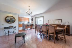 una cucina e una sala da pranzo con tavolo e sedie di GuestReady - Paracoba House a Moledo