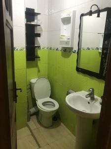 a green bathroom with a toilet and a sink at Appartement Familial a 3min de la gare routiere Tanger in Tangier