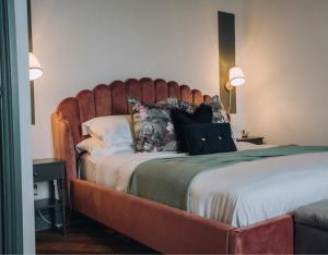 a bed with a large wooden headboard in a room at Pebble View - Central Cosy with Sea-Views in Weymouth