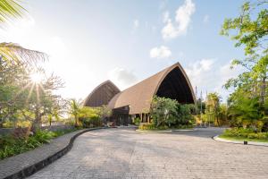 a building with a pointed roof and a road at MERUSAKA Nusa Dua in Nusa Dua