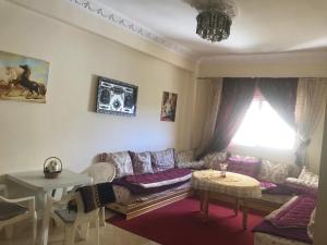 a living room with a couch and a table at Appartement Familial a 3min de la gare routiere Tanger in Tangier