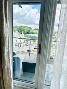 a sliding glass door with a view of a balcony at Modern Flat with En-suite and Free Parking in Chatham