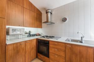 Una cocina con armarios de madera, fregadero y microondas. en GuestReady - Chapel`s Garden, en Caminha 45 fotos más