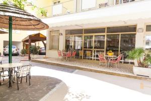 a restaurant with tables and chairs outside of a building at Hotel Corallo in Gatteo a Mare