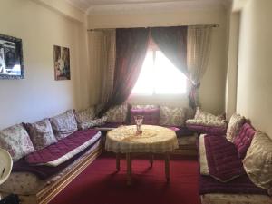 a living room with a couch and a table at Appartement Familial a 3min de la gare routiere Tanger in Tangier