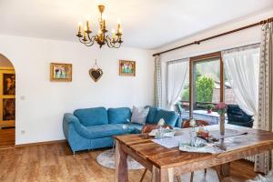 uma sala de estar com um sofá azul e uma mesa em Aschaubichl - Wohnung Alpenrose em Grainau