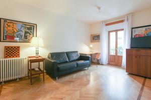 a living room with a couch and a television at Romantic Spiga Suite in Milan