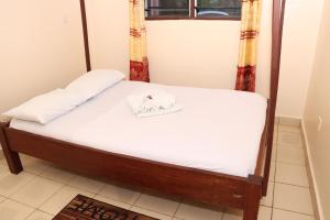 سرير أو أسرّة في غرفة في Pebbles guesthouse in Diani beach road