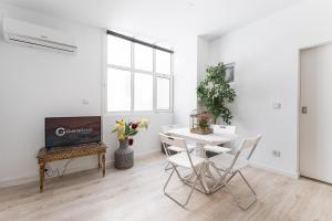 a white living room with a table and a fireplace at GuestReady - Gold Leaf in Porto