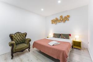 a bedroom with a bed and a chair at GuestReady - Gold Leaf in Porto +40 photos