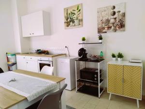 una cucina con armadi bianchi, tavolo e tavolo e una cucina di Appartamenti La Rocchicciola ad Assisi