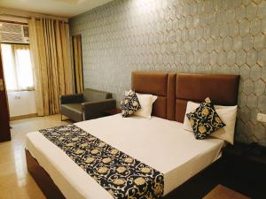 a bedroom with a bed and a chair at Hotel IVY Near IGI Delhi Airport in New Delhi