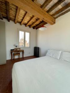 a bedroom with a large white bed and a table at Altana della Ruggera in Modena