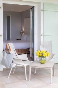 サント・マリー・ド・レにあるAtalante Relais Thalasso & Spa - Wellness Hôtelの椅子2脚、テーブル1台、ベッド1台が備わる客室です。