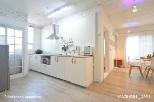 a kitchen with white cabinets and a table in a room at Villasis - Our oasis in Hot Hongdae 301 or 401 in Seoul