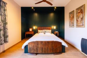 a bedroom with a large bed with a wooden headboard at Clos des Poulies in La Ferté-Saint-Aubin