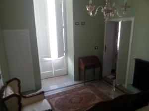 Habitación con lámpara de araña y pasillo con puerta. en Casa Ginevra, en Monopoli