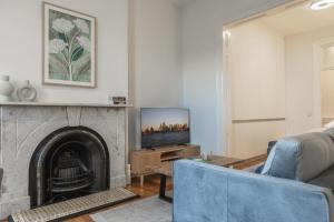 a living room with a fireplace and a blue couch at Modern 1-Bed Studio near Tramsheds in Sydney