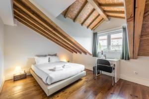 une chambre avec un lit blanc et un bureau dans l'établissement GuestReady - Porto Home GuestHouse, à Porto