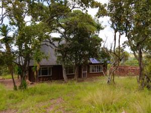 a house in the middle of a field with trees at Masungulo Lodge in Modimolle