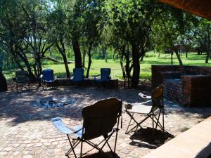 a group of chairs sitting around a fire pit at Masungulo Lodge in Modimolle