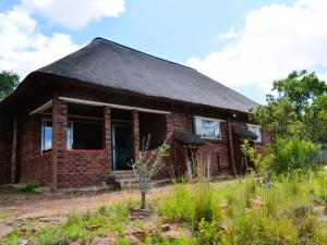 una casa de ladrillo con techo negro en Masungulo Lodge, en Modimolle