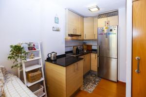 uma pequena cozinha com um frigorífico de aço inoxidável em BRISA Planet Costa Dorada em La Pineda