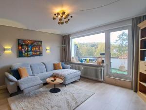 a living room with a couch and a large window at Das kleine Penthouse mit Kamin in Bad Sachsa