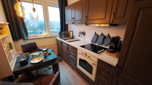 a kitchen with a counter and a table in it at Das kleine Penthouse mit Kamin in Bad Sachsa